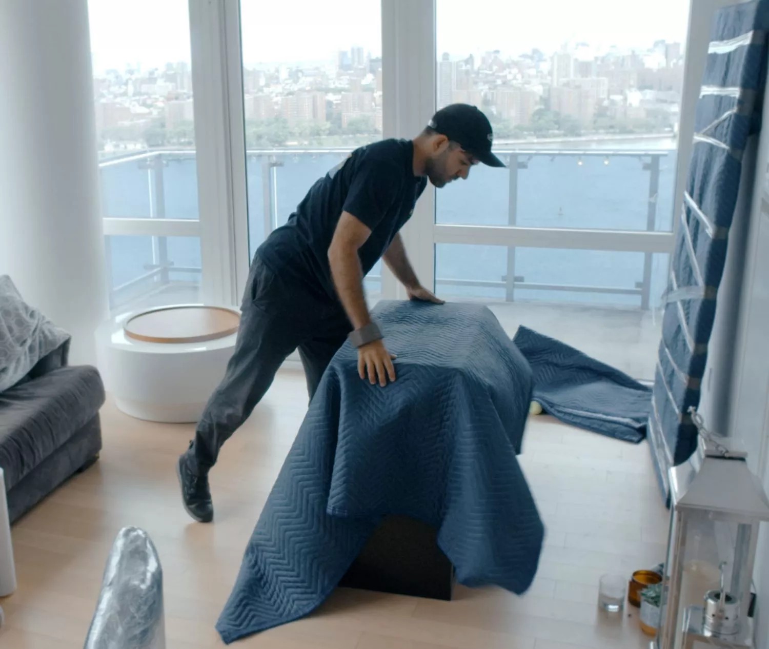 Manhattan movers wrapping furniture in padded blanket