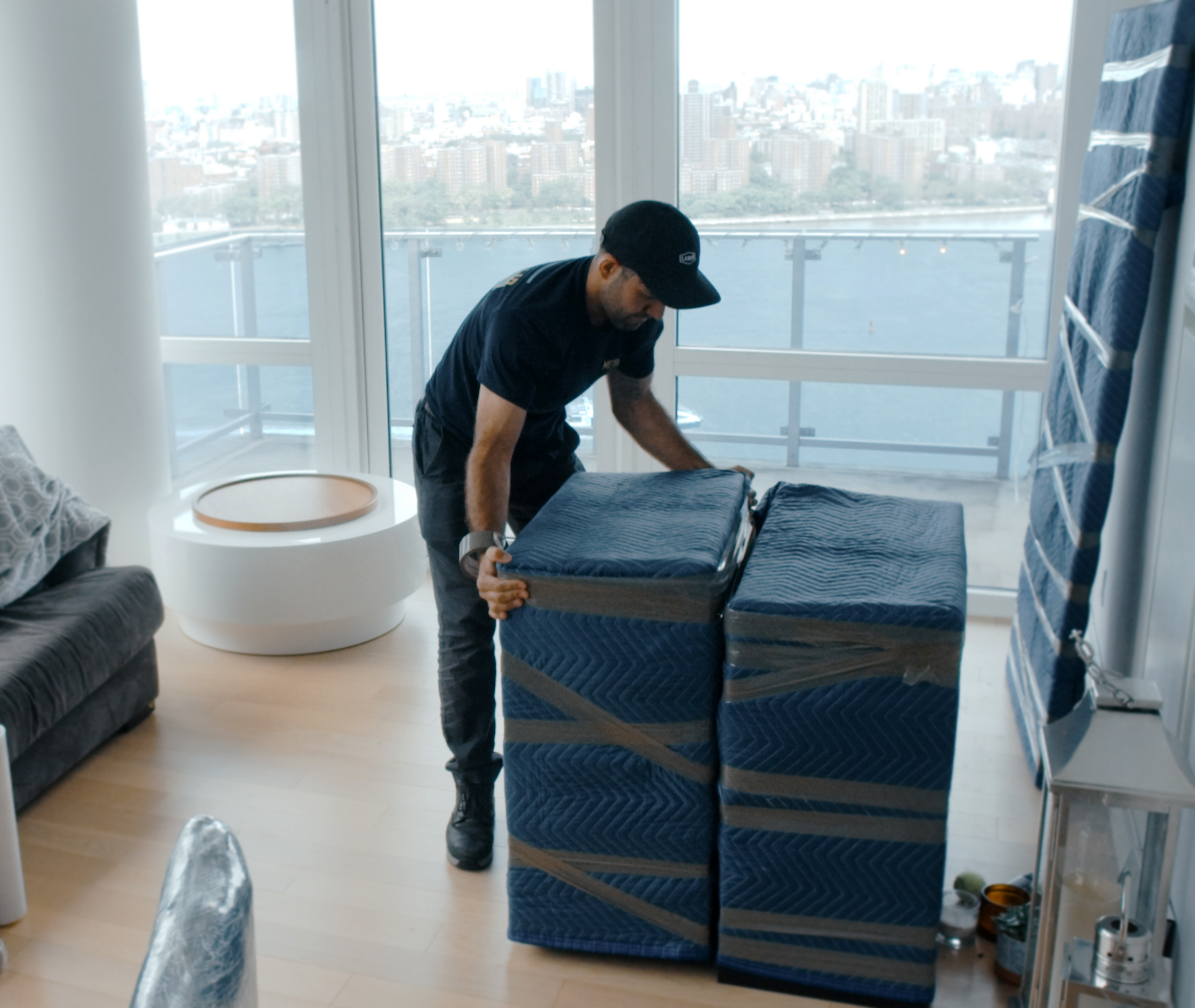 Manhattan movers wrapping furniture in padded blanket