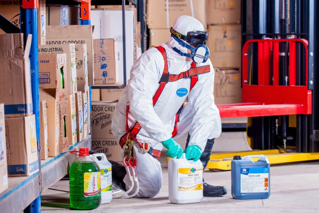 man in protective gear preparing cleaning chemicals
