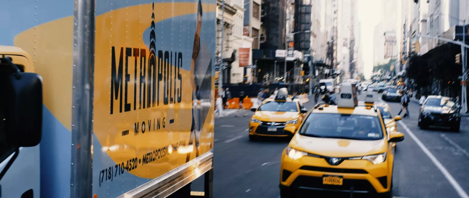Metropolis moving truck driving in traffic in Midtown Manhattan, NYC