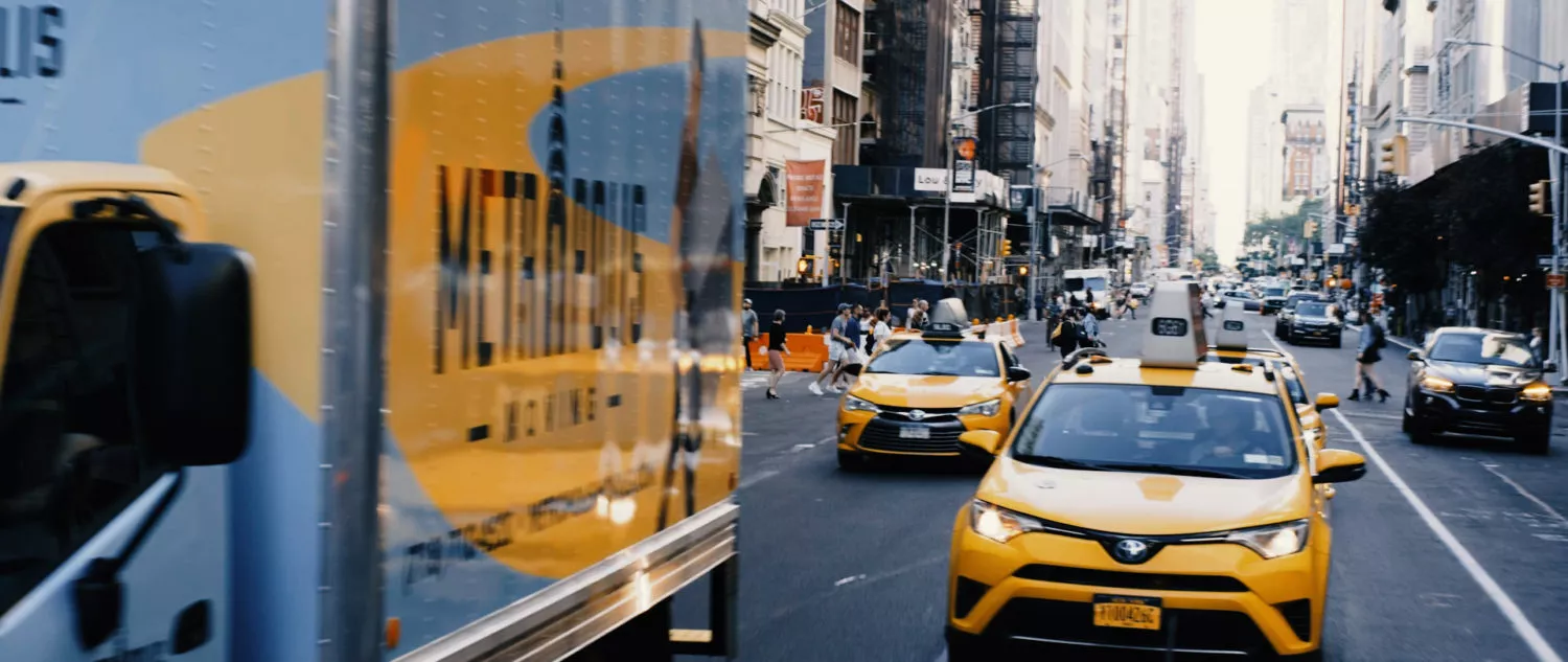 Metropolis moving truck driving in traffic in Midtown Manhattan, NYC