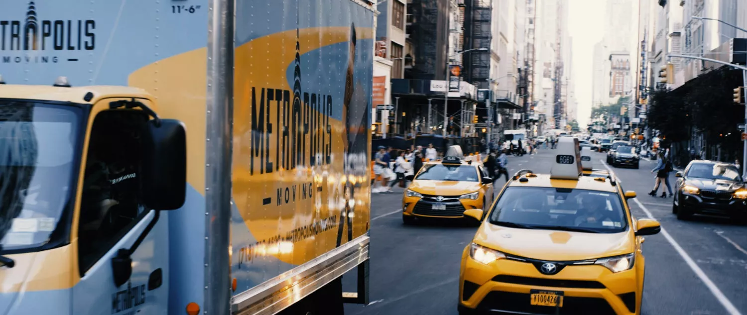 Metropolis moving truck driving in traffic in Midtown Manhattan, NYC