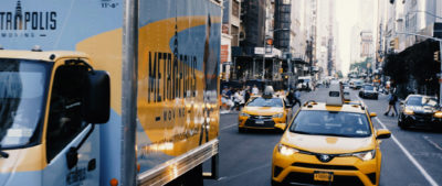 Metropolis moving truck driving in traffic in Midtown Manhattan, NYC