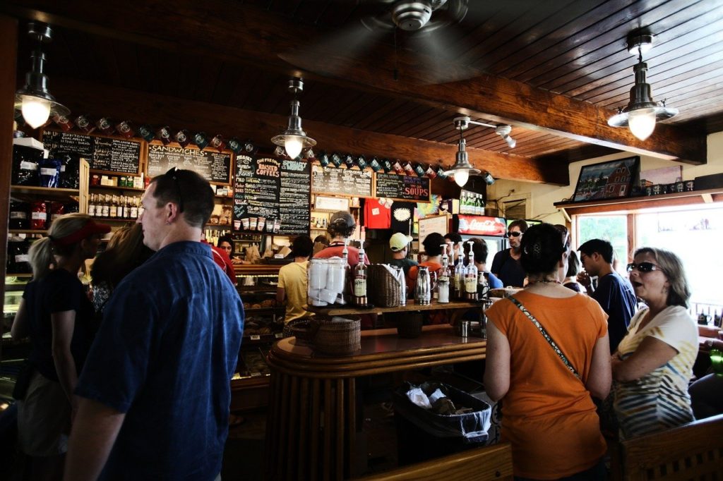 classic wooden pub with patrons standing around waiting for their beverages