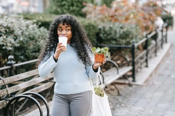 content young woman walking through a park in jamaica estates
