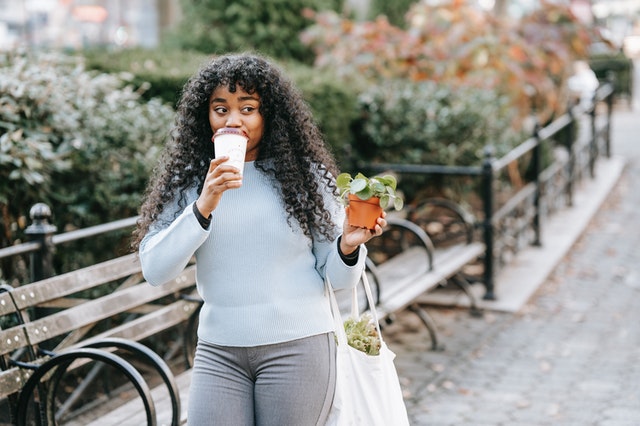 content young woman walking through a park in jamaica estates