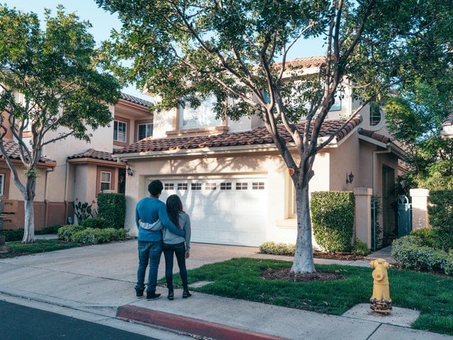 young homeowners in the driveway of the home they just bought