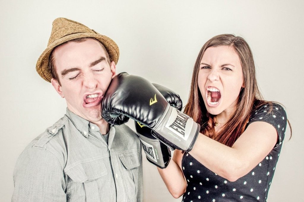 woman hitting a man with boxing glove