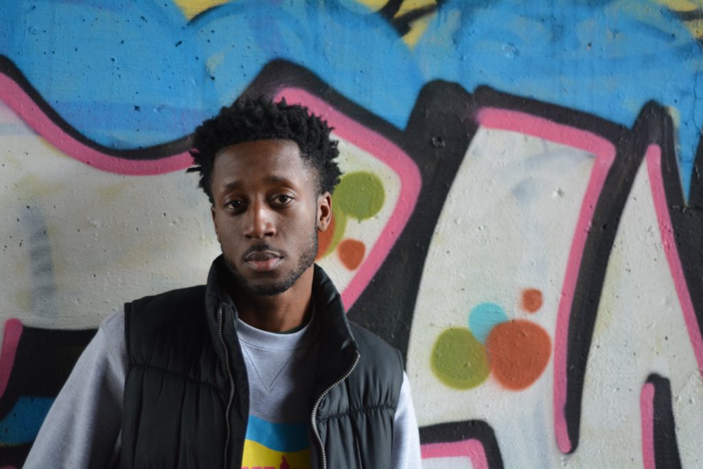 man standing in front of graffiti