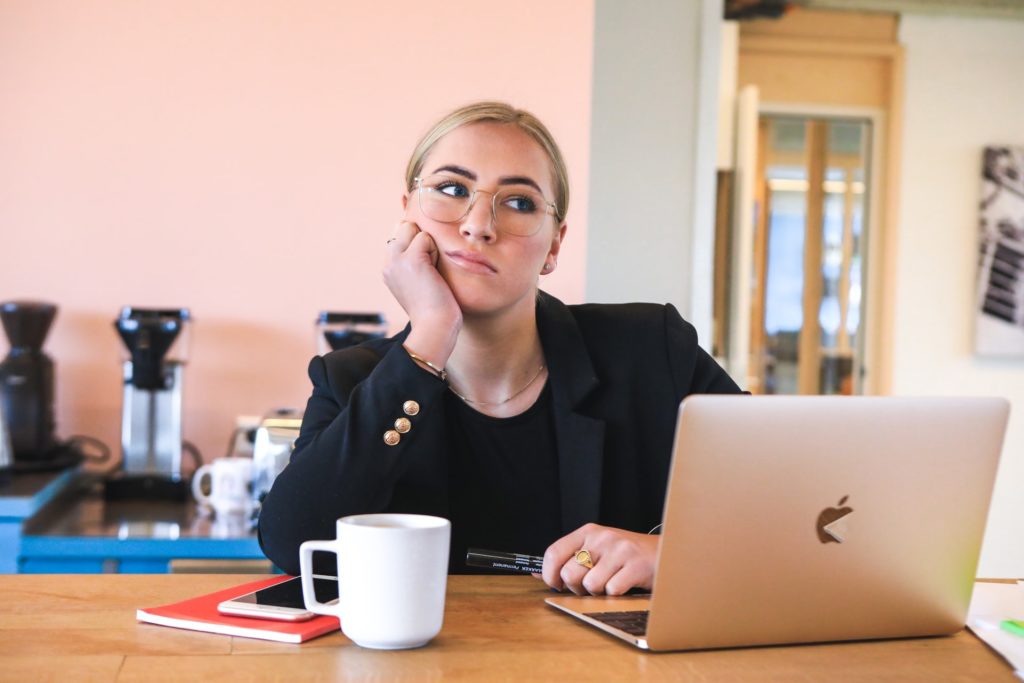 woman sitting at her desk looking bored