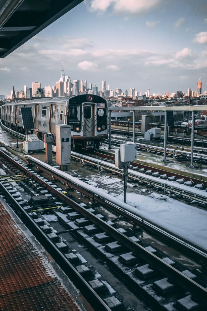 nyc subway with skyline in the background