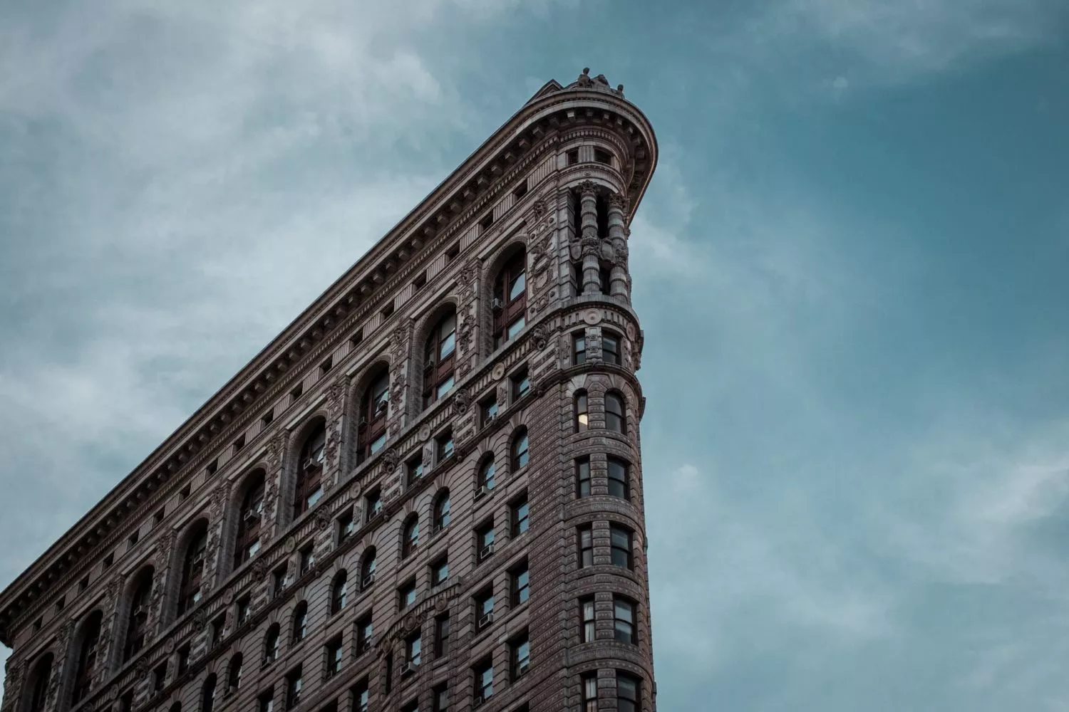 the flatiron building set against a dark cloudy sky