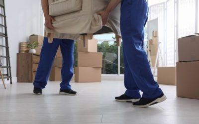 the lower half of two movers caring furniture out of an NYC apartment