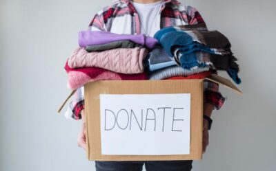 a person holding a box of clothes marked, 